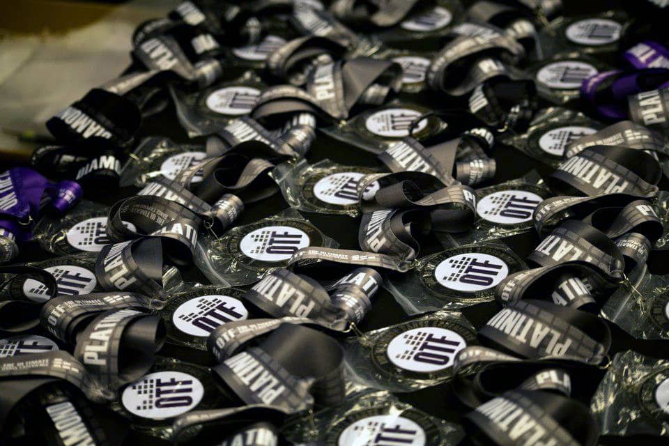 A table full of OTF branded winners' medals