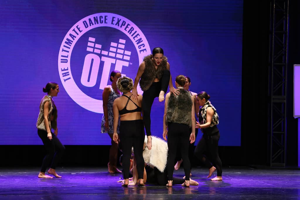 A group of dancers performing an acrobatic routine during an On The Floor Decipher event