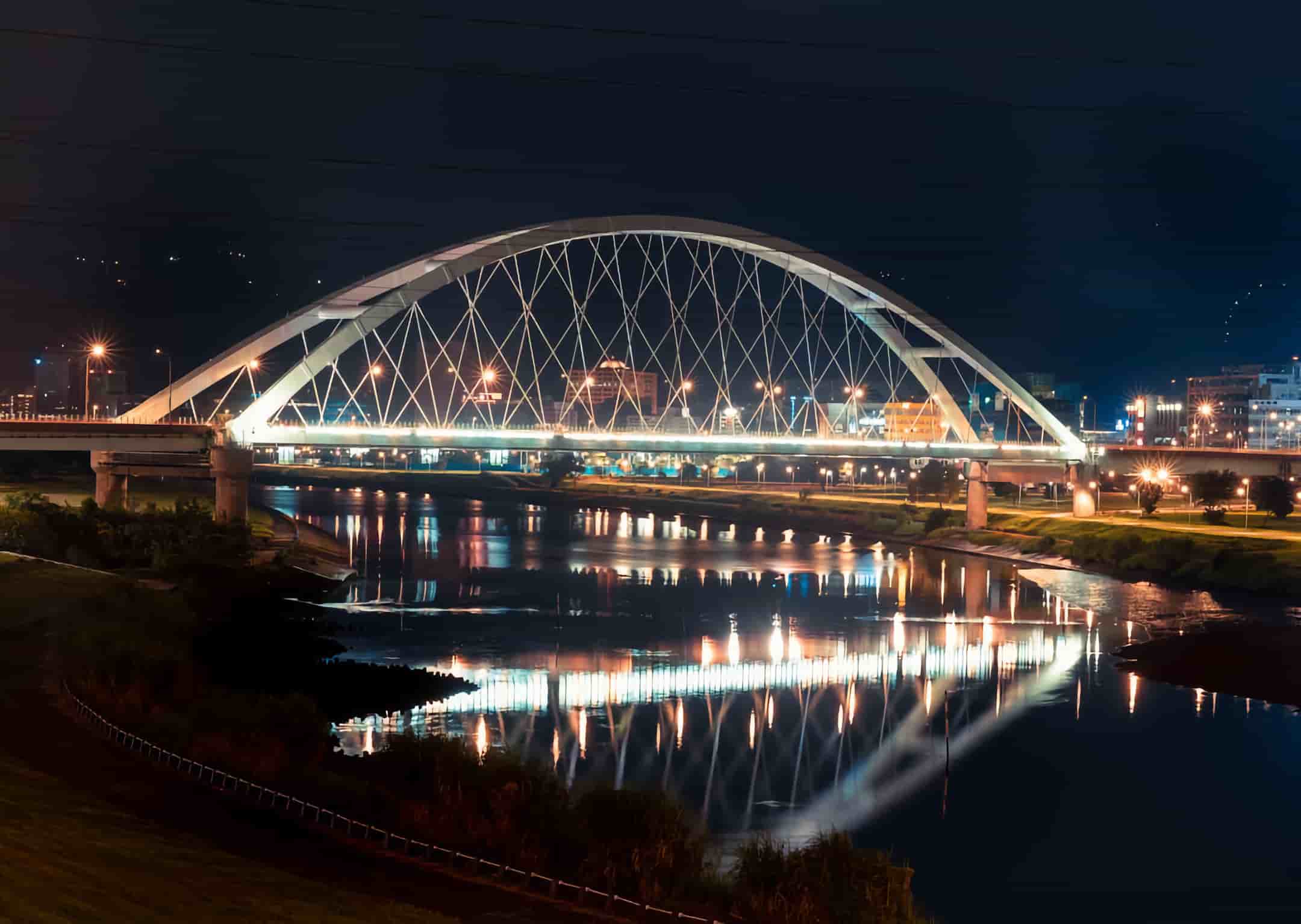 A nighttime view of an illuminated bridge in Edmonton
